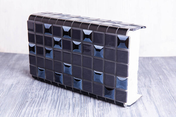 A black tile with blue glossy inserts