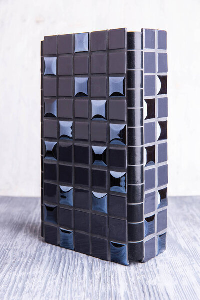 A black tile with glossy inserts