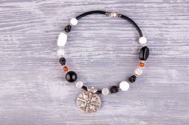 Bir kolye cazibe ile oyulmuş boncuk kristal, amber ve beyaz renkteki aragonit ekler