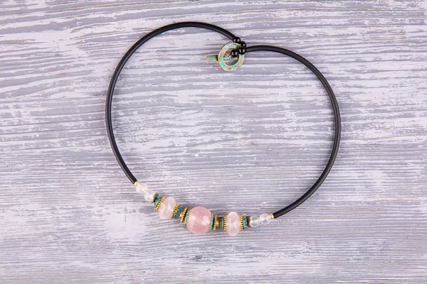 A necklace on a rubber cord with natural rose quartz
