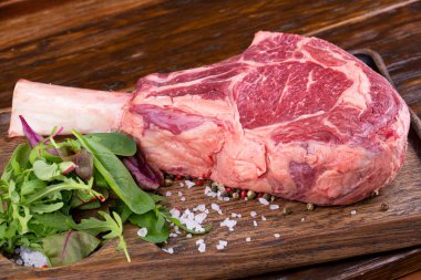 Kemiğin üzerinde çiğ sebze ve baharat var.