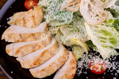 Sezar, tavuklu, domatesli, krem soslu ekmek kırıntılı ve peynirli.