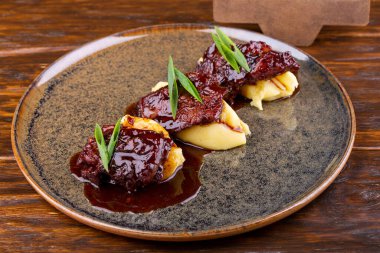 Kızarmış biftek, patates püresi, sos ve yeşil soğan.