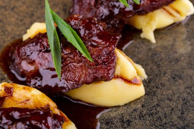 Et soslu ve patates püresi, taze yeşillikle servis edilir.