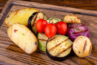 Izgara sebzeler zeytin yağı tahtasında servis edilir.