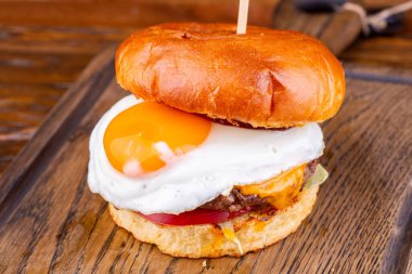 Mermer biftekli hamburger, peynir, domates, marul yaprağı ve yumurta.