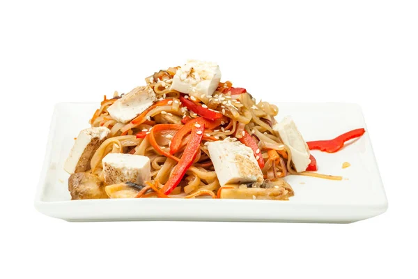 Chinese noodles with tofu and vegetables on a square plate isolated from background