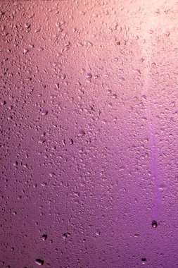 Yağmurlu pencere. Pembe camına geri ışık çekiliyor
