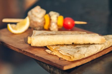 Kiraz domates ve limon ahşap kesme tahtası üzerinde pide ekmek ve balık Barbekü.