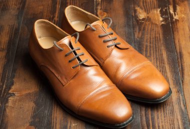 Erkek ayakkabıları bir ahşap zemin üzerinde şık çift deri