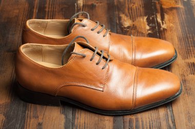 Erkek ayakkabıları bir ahşap zemin üzerinde şık çift deri