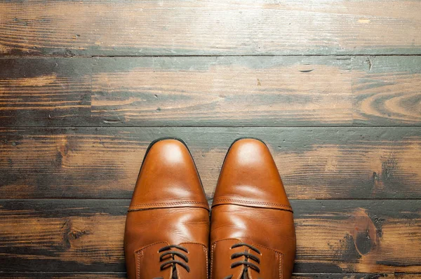 Erkek ayakkabıları bir ahşap zemin üzerinde şık çift deri