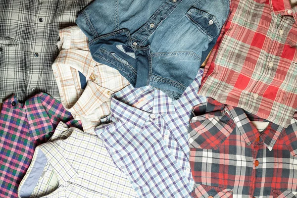 Lot of different checkered shirts. Cloth wallpaper