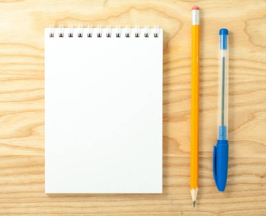 Ahşap Resepsiyon zemin üzerine açık sarmal boş defter kalem ve kurşun kalem ile üstten görünüm