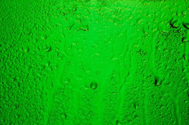 Yağmurlu pencere. Yeşil arka ışık camının damla