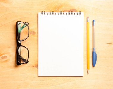 İş gerekli. Ahşap Resepsiyon arka plan üzerinde sarmal boş defter üstten görünüm