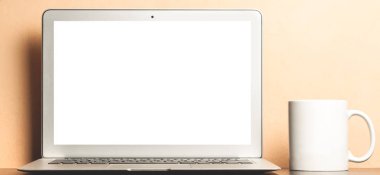 Boş ekran ve beyaz Kupası ile modern dizüstü bilgisayar. Mockup için arka plan.