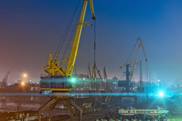 Portal vinçler ve yüksek hızlı deniz otobüsü gece limanda gemi