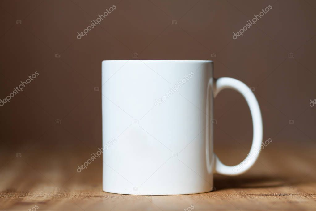 Stylish white mug on the wooden table