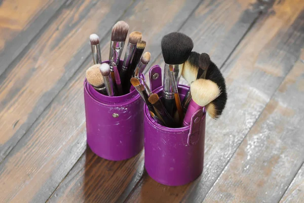 Professional makeup brushes in tube. Dirty makeup tools.