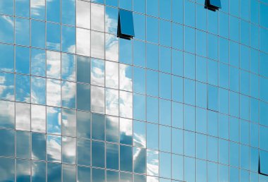 Modern binanın cam cephe. Bulutlu gökyüzü cam yansıtır