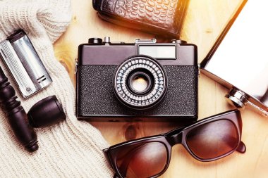 Yaratıcı kişinin aksesuarları. 35 mm ince tabaka fotoğraf makinesi, pozometre deri çanta, çelik flask, güneş gözlüğü ve ahşap arka plan üzerinde ayarla yasaktır.