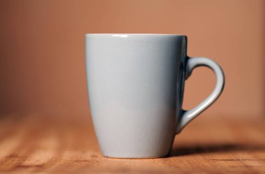 Ahşap masa üzerinde gri kupa. Office çalışma alanı arka plan