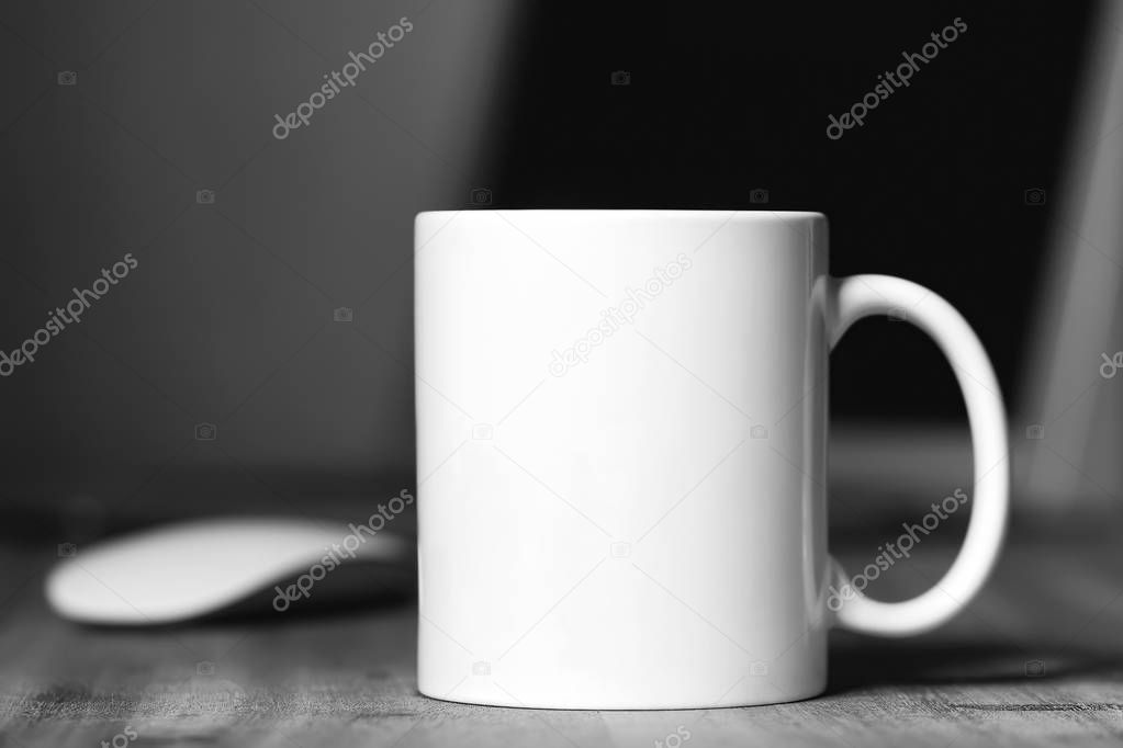 White mug on the wooden table. Office workspace background