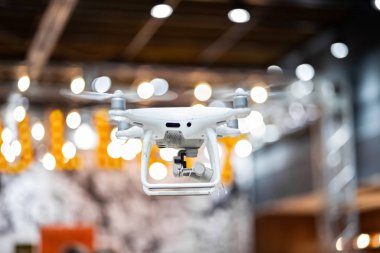 Beyaz dron hareket. Büyük bir depo içinde uçan Quadcopter