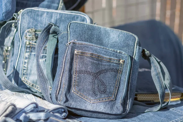 Blue denim bags with a pocket are on the counter