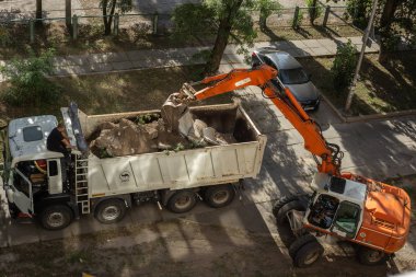 Kiev, Ukrayna, 16 Eylül 2018. Eski beton yapıların damperli kamyon bir ekskavatör ile yükleme.