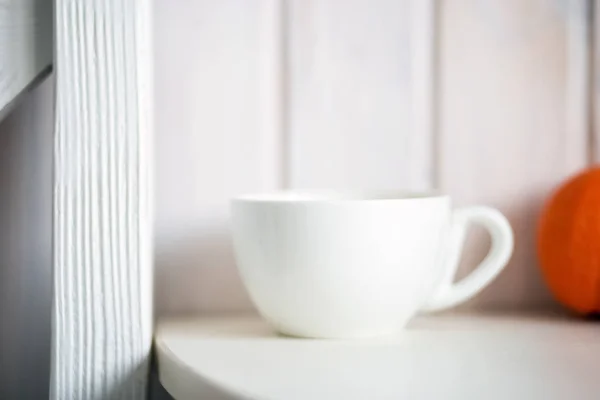 Blank white mug on kitchen table. Background for mockup.