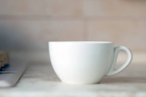 Blank white mug on kitchen work surface. Background for mockup