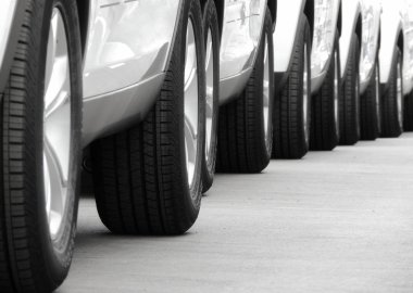 Ortaya konulan yeni beyaz arabaların tekerlekleri asfalt üzerinde çizgiler 