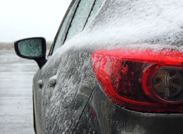 雪と氷の冬の日に屋外で覆われた灰色の車の後部背部ライト — ストック写真