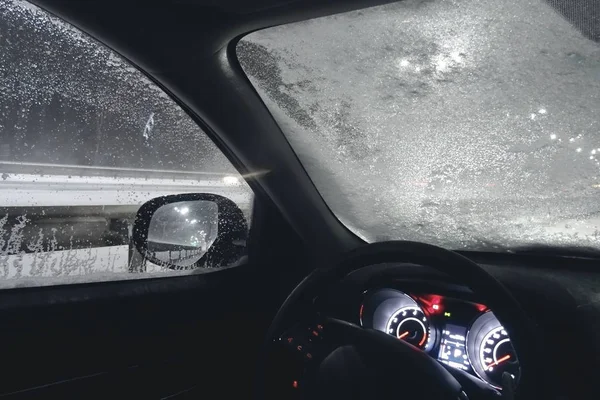 夜の道路上の車の冷凍のフロント ガラスに雪と氷 — ストック写真