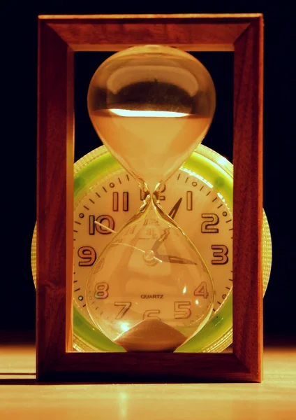 タイムグラスの後ろの目覚まし時計 — ストック写真