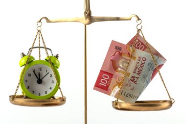 Terazinin bir tarafında 100 peso, diğer tarafında da çalar saat var.