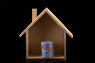 10,000 Kazakistanlı banknot ve siyah arka planda sembolik ahşap bir ev.