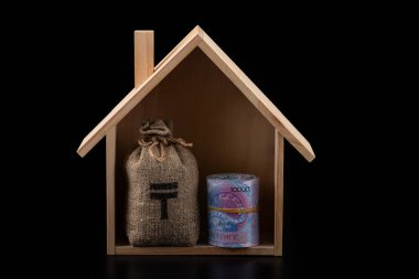 10,000 Kazakistanlı banknot ve siyah arka planda sembolik ahşap bir ev.