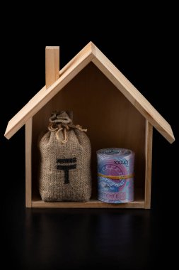 10,000 Kazakistanlı banknot ve siyah arka planda sembolik ahşap bir ev.