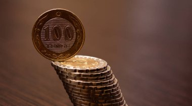100 Kazakistan tenge sikkesi eğik bir madeni para sütunu üzerinde