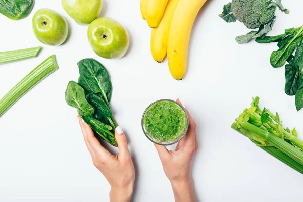 View from above woman's hands holding bunch spinach