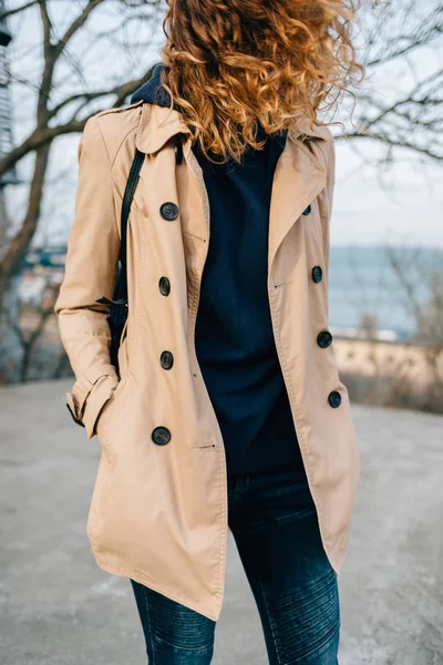 Unrecognizable young woman wearing beige trench coat