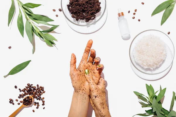 View from above female\'s hands applying homemade coffee scrub