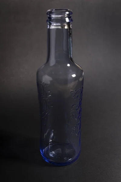 transparent blue empty water bottle on a black background