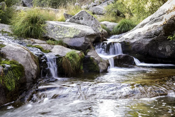 Small rapid waterfalls created by a river when passing between stones — Stock Photo, Image