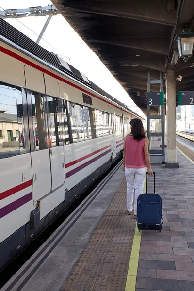 Mulher andando em uma estação de trem — Fotografia de Stock