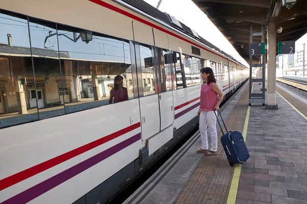 Femme attendant le train avec une valise — Photo