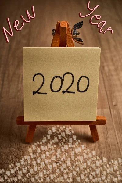 Wooden lectern with a sheet with the text New Year 2020 — Stock Photo, Image